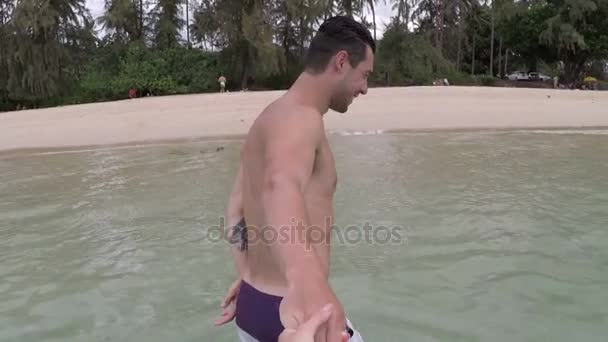 海辺に若いカップルのコミュニケーションのアクション カメラ Pov を話の手を握って水からのビーチで男散歩 — ストック動画