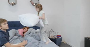 Anne, mutlu aile yatak odasında sabah uyku ile yatağa yastık sahip çocuklar kavga