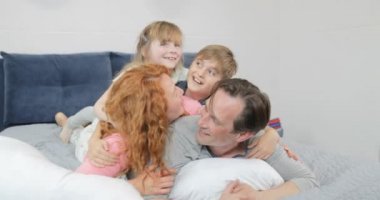 Mutlu gülümseyen aile yatak odası çocuklar ve ebeveynler iletişim birlikte sabah babası yatakta yatarken
