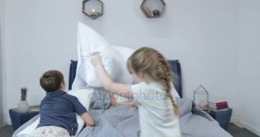 Yastık sahip çocuklar ebeveyn yatak, yatak odasında mutlu aile eğlenceli mücadele