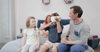 Aile evlat oyun oyunlar sanal gerçeklik gözlüklü yatak odasında bakarak, ebeveynler ve çocuklar sabah birlikte evde geçirmek