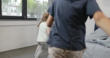 Mutlu çocuklar sabah, yatak odasında neşeli aile anne ve baba anne yatağa atlamak