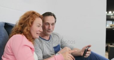 Yetişkin çift yatakta birlikte aile yatak odasında oynayan çocukların üzerinde akıllı telefonu kullanarak