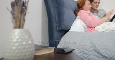 Ne zaman kadın telefon görüşmesi dijital Tablet kullanarak yatakta yatarken coupe