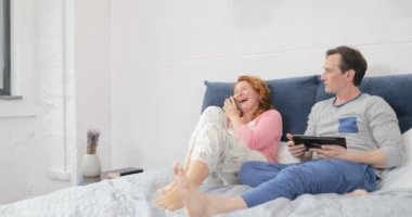 Kıskanç adam kadına cep telefonuyla konuşan bakan ara yatak çift yatak odasında gülen oturan