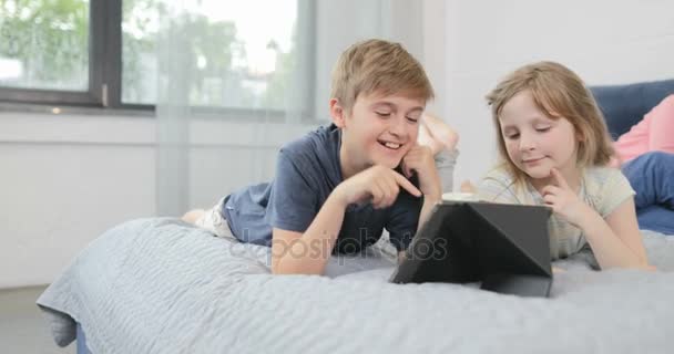 Γιος κρεβάτι χρήση υπολογιστή Tablet ψέματα στους γονείς πάνω χαμογελά ευτυχισμένη οικογένεια μαζί πρωί — Αρχείο Βίντεο