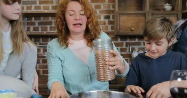 Mutlu aile mutfak ebeveynler ve çocuklar yemek hazırlama sırasında konuşmak içinde birlikte sağlıklı yemek pişirme