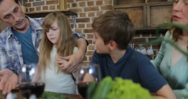 Семья разговаривает во время приготовления пищи на кухне Родители Общение с детьми Подготовка пищи дома к ужину — стоковое видео