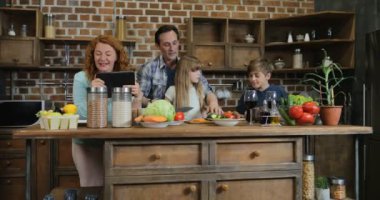 Birlikte yemek tarifi kullanarak Tablet bilgisayar anne mutfakta iki çocukla hazırlamak yemek evde aile