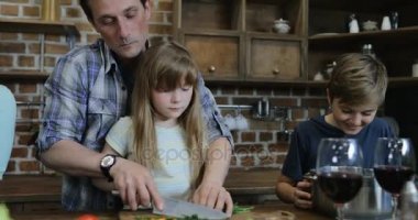 Baba ve kızı birlikte oğlu evde iletişim anne kullanarak Tablet dijital bilgisayar mutlu aile süre ile konuşurken mutfak pişirme sebze doğrama