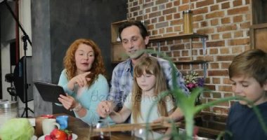 Ebeveynler birlikte mutfakta, mutlu aile hazırlanıyor gıda birlikte Tablet bilgisayar kullanarak tarifi yemek çocuk eğitimi