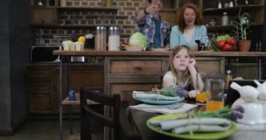 Tablet bilgisayar, mutlu aile birlikte yemeden önce mutfakta yemek yemek için bekleyen masada oturan çocukların kullanımı