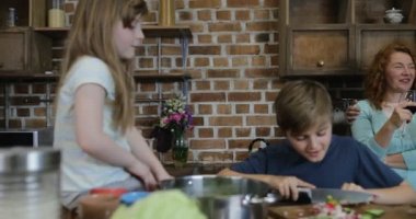 Mutlu gülümseyen veliler Çocuklara kesme sebze birlikte mutfak aile yemek gıda ev arıyorum
