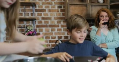 Mutlu çocuk yemek şarap, neşeli aile gıda birlikte mutfakta hazırlama içme ailesiyle konuşurken salata