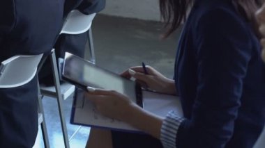 Meslektaşları ile oturan seminer sunumu dinlerken dijital Tablet bilgisayar tutan iş kadın