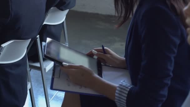 Kobieta biznesu, trzymając komputer cyfrowy Tablet słuchania prezentacji na seminarium siedzący z kolegami — Wideo stockowe