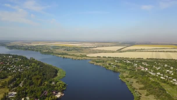 Вид с воздуха на Голубую реку с маленькой деревней и полями на берегах, беспилотник с сельским летним пейзажем — стоковое видео