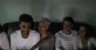 İnsanlar konuşuyor, genç neşeli arkadaşları iletişim Tv programı izlerken kanepede oturan grup