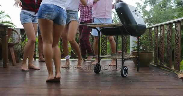 Jovens dançando enquanto cozinham churrasco Frineds Group Reunião no terraço de verão com pernas de festa Vista de close-up — Vídeo de Stock