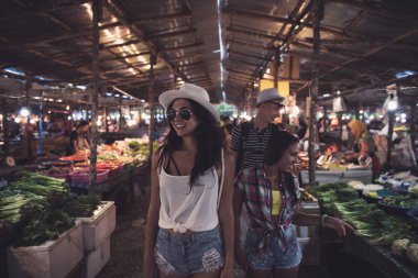 Seçme taze meyve ve sebze Asya ın Bazaarı tropikal egzotik Pazar genç satırları arasında yürüyen turist insanlar