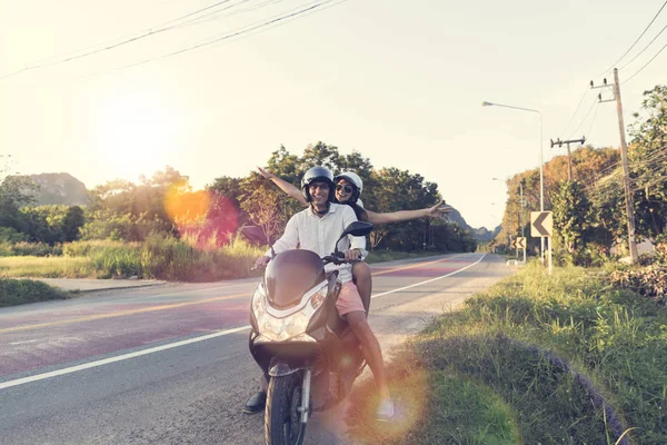 对幸福的夫妇骑摩托车在农村很激动的女人和男人乘坐摩托车公路旅行 — 图库照片