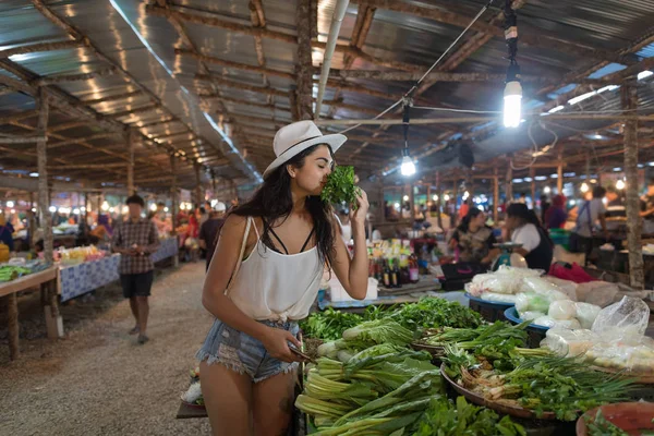 Joven mujer oler hierbas elegir verde potherbs en mercado chica compras en calle bazar —  Fotos de Stock