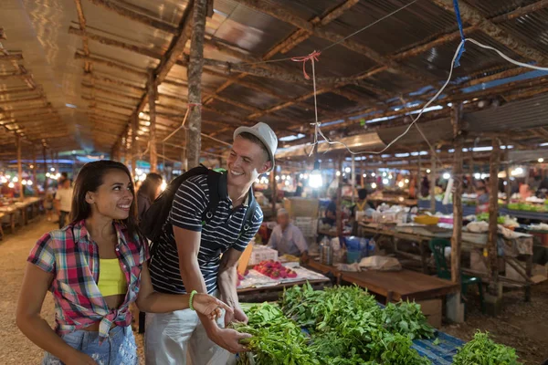 Pareja joven elige hierbas en el mercado de verduras Happy Smiling Man and Woman Shopping Together On Street Bazaar — Foto de Stock