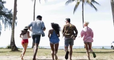 İnsanlar denize geri arkadan görünüş, mutlu bir genç adam ve kadın arkadaşlar eller yükselterek plajda çalışan grup