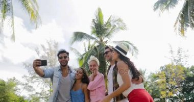 İnsanlar grup palmiye ağaçları, mutlu gülümseyen Mix yarış adam ve kadın iletişim altında açık havada akıllı cep telefonuyla Selfie fotoğraf çekmek