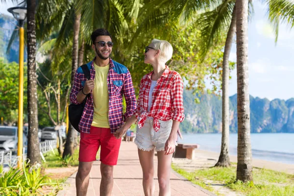 Couple décontracté se tenir la main en marchant dans le parc tropical de palmiers, beaux jeunes en vacances d'été — Photo