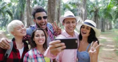 İnsanlar Selfie fotoğrafta cep telefonundan grup telefon zammı, erkek ve kadın tropikal palmiye ağacı ormanda yürüyüş üzerinde akıllı