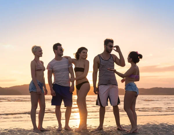 Giovani gruppo sulla spiaggia al tramonto vacanze estive, felici sorridenti amici a piedi sul mare — Foto Stock