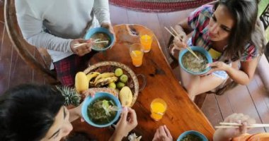 Delicious erişte çorbası Asya gıda, arkadaş grubu yem yeme insanlar birbirlerini tablo üst açılı görünüş oturmak