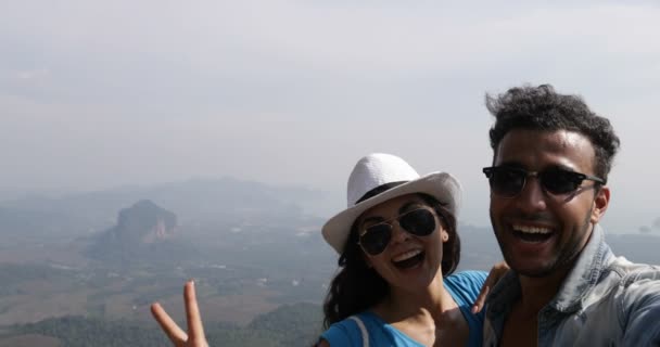 Couple Taking Selfie Photo On Mountain Top Happy Smiling Over Beautiful Landscape POV, Mix Race Man And Woman Tourists — Stock Video