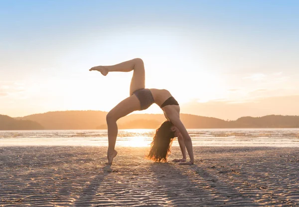 Genç kızı pratik yoga, gün batımı, güzel bir kadın yaz tatili meditasyon Seaside Beach