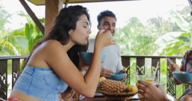 Konuşan insanlar yemek Noodles, arkadaş grubu tropik orman manzaralı terasta masaya oturmak