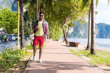 Genç İspanyol adam yürüme tropikal plaj deniz tatil adam mutlu gülümseyen yaz tatili