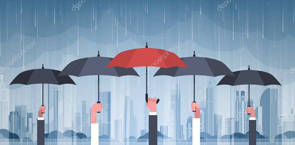 Grupo de manos sosteniendo paraguas sobre tormenta en ciudad lluvia