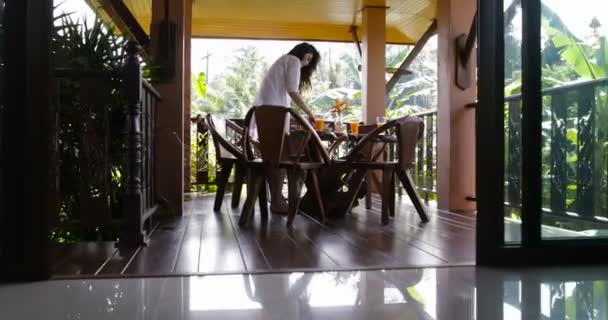 年轻的女孩为早餐食品服务夏季露台，女人在早晨的阳光，户外用餐的准备 — 图库视频影像