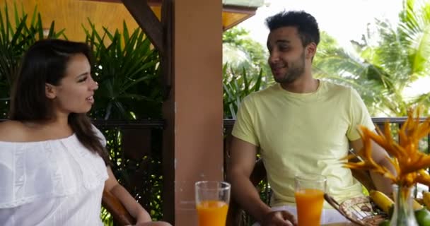 Ευτυχισμένο ζευγάρι κάθεται στην καλοκαιρινή βεράντα, μιλώντας, νεαρός άνδρας και γυναίκα επικοινωνίας κατά τη διάρκεια του πρωινού — Αρχείο Βίντεο