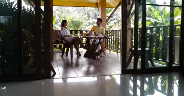 Lyckliga paret pratar sittande vid bord på sommarterrassen, ung Man och kvinna kommunikation under frukosten — Stockvideo