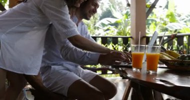 Mutlu çift yaz terasında tipik haber birlikte, tablo mutlu gülümseyerek oturan kadın kucaklayan adam dizüstü bilgisayar kullanarak