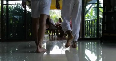 İki adamın içme suyu, in arkadaş grubu ile sabah masada oturan Teras birleştirmek genç kızlar için yürüyüş geri arka görünüm