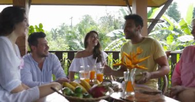 Yaz terasında konuşmak, farklı arkadaşlar suyu içme masada oturan birlikte mutlu insanlar grubu