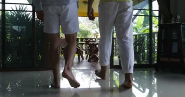 Tablo konuşmakta oturan Teras üzerinde yürüyen iki adam portakal suyu, Mix yarış eşcinsel çift Villa tropikal ormanda sabah iç