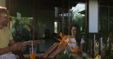 Erkek ve kadın ile suyu gözlük gülümseyen tezahürat, mutlu konuşmaya terasta masada oturan Çift