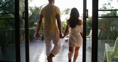 Günbatımı konuşurken tutuşup geri, terasta arkadan görünüş, mutlu bir adam ve kadın açık havada yürüyüşe Çift