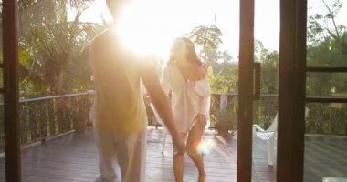 Adam Teras tropikal orman, mutlu çift açık havada kucaklayan günbatımı manzara bakmak için önde gelen genç kadın