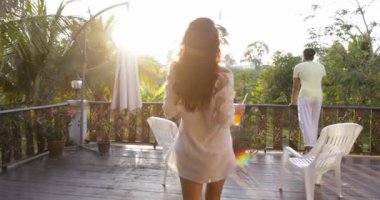 Geri arka suyu ile yaz terasında genç kadın yürüyüş günbatımı manzara bitti tropik orman bakan adam için görünümünü