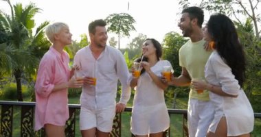 Mix yarış grup günbatımı, genç erkek ve kadınların içme suyu konuşuyor terasta ayakta iletişim arkadaşıyla